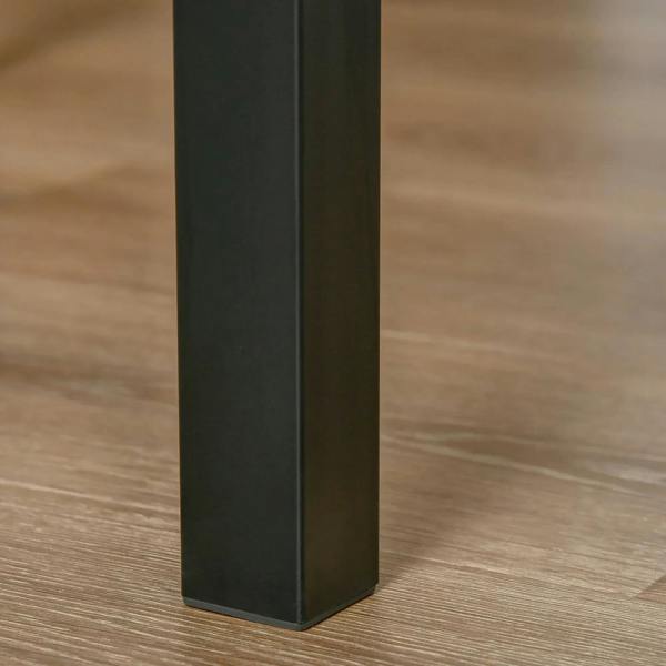 Close-up of black metal dining table leg on light wood surface