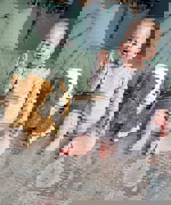 Little girl in living room with Peanut Pup Pull Along toy 