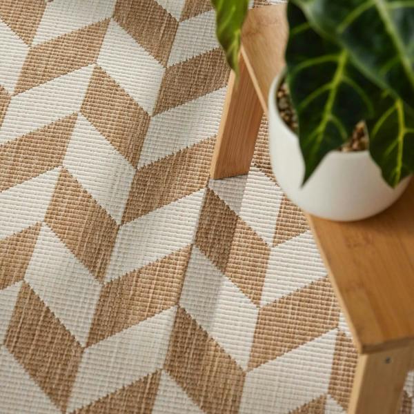 Geometric patterned rug with a wooden chair and plant in the corner