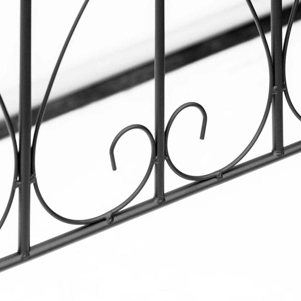 Close-up of black metal fence rail with curled scroll ornament and vertical posts