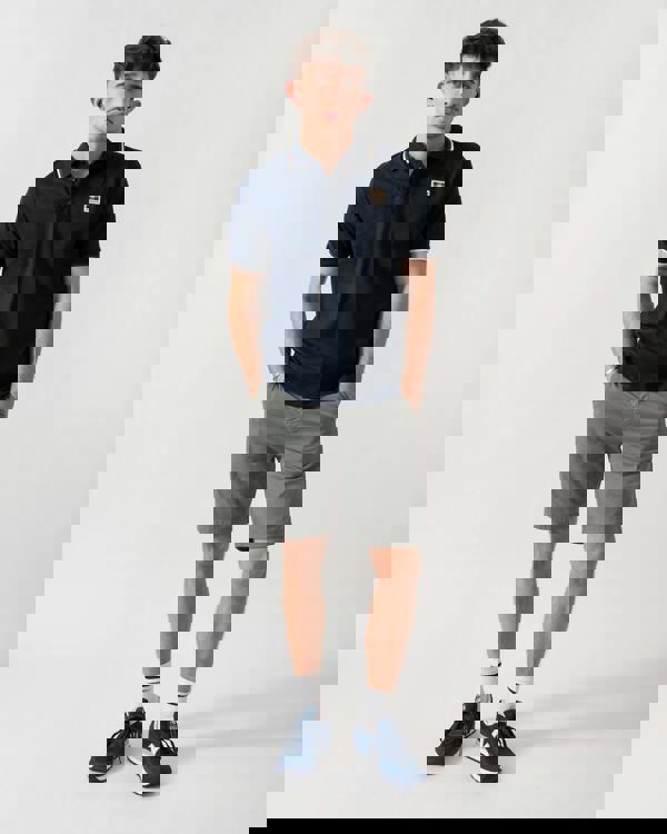 full length shot of a model wearing an Aquascutum Mens Stretch Piquet Tipped Badge Polo Shirt in Navy 11