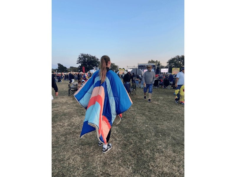 A girl in a field at a festival wearing the  Limited Edition OLPRO Ocean Sunset Blanko