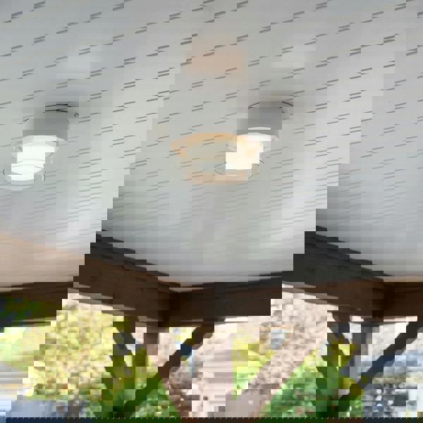 white outdoor ceiling mount light mounted under the outdoor canopy of a house