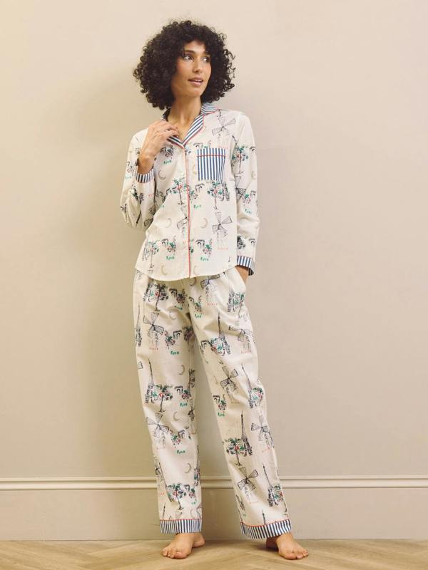 Woman wearing a navy and white Paris print pyjama set against a plain background