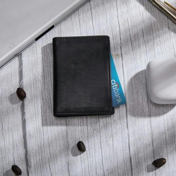 Black card holder on a light wooden surface with coffee beans.