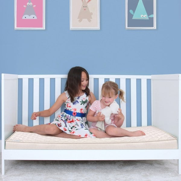Natural pocket sprung mattress in a cot 