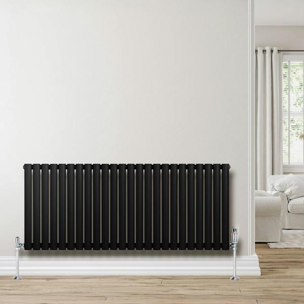 Sleek black oval single column radiator with chrome valves, 600mm x 1440mm, mounted against a light wall in a modern room