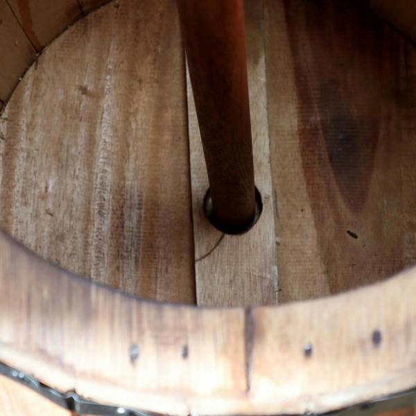 Close-up of barrel interior with upright wooden post and visible plank seams