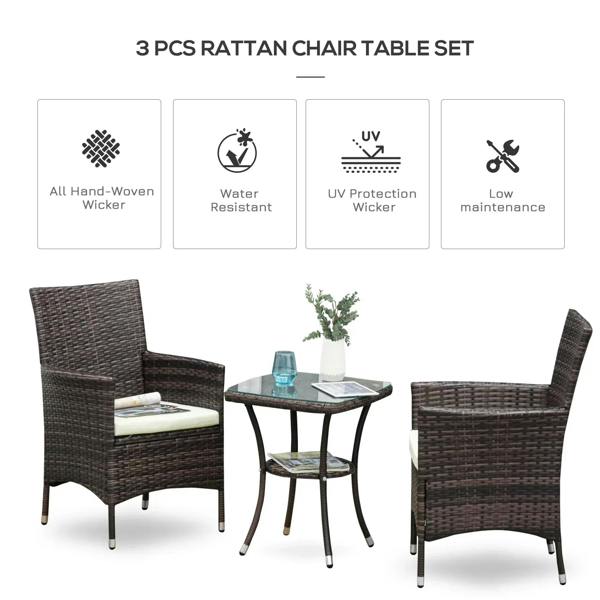 Three-piece rattan chair set with round glass-top table and white cushions