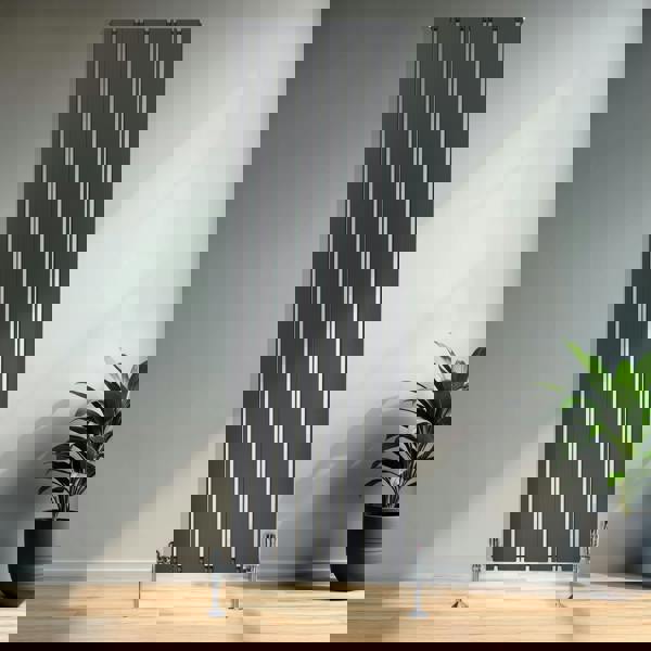 Flat single column radiator in anthracite grey, featuring vertical slats and a sleek design, positioned against a modern interior wall