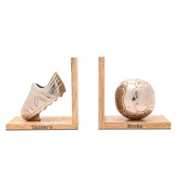 A pair of personalised wooden football bookends showing an engraved base reading 'Tanner's Books' with a metallic football boot and ball.