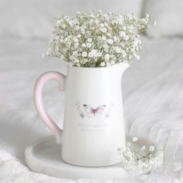 White ceramic flower jug with pink handle and butterfly print