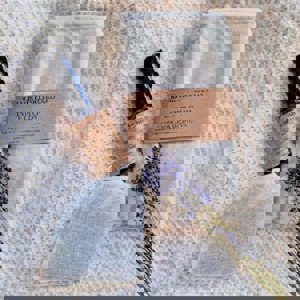 Ralph's Orchard eye pillow and essential oil bottle on a textured surface with lavender.