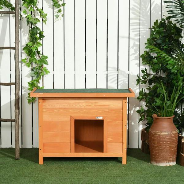 Elevated wooden dog kennel with open front entrance and flat top, yellow exterior