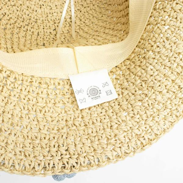Beige straw sun hat with woven band and fabric tag on the underside