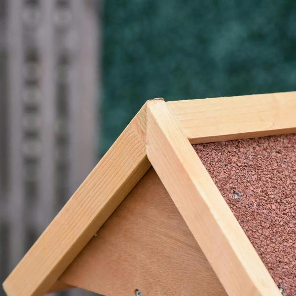 Close-up of wooden bird feeder roof frame with textured felt panel and small fasteners