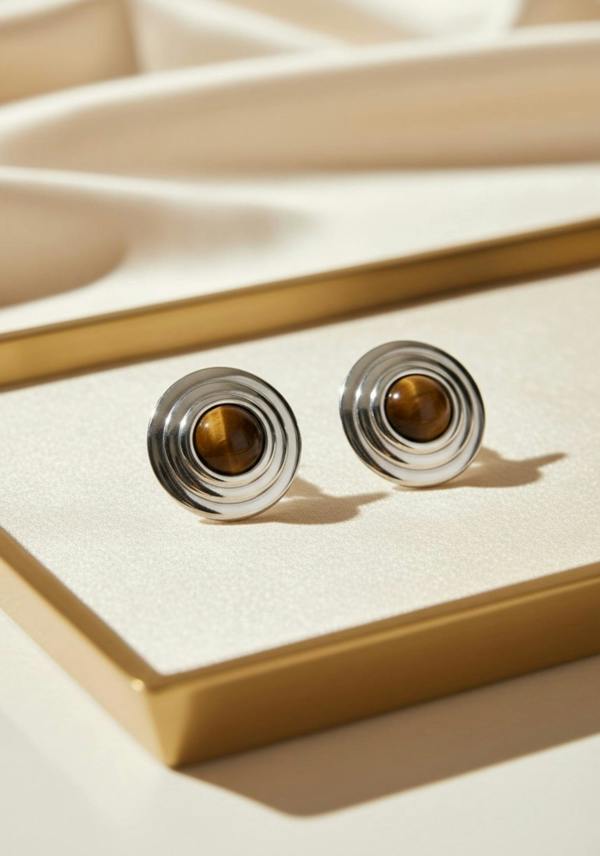 Pair of earrings with brown gemstones on a beige surface