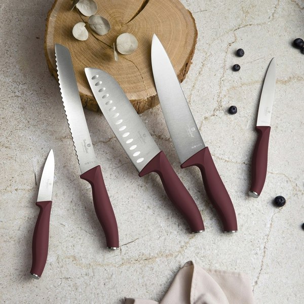 A set of five stainless steel kitchen knives with maroon handles, including a chef's knife, a bread knife, and a paring knife.