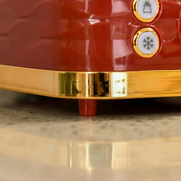 Close-up of red kettle base with gold trim and control dials