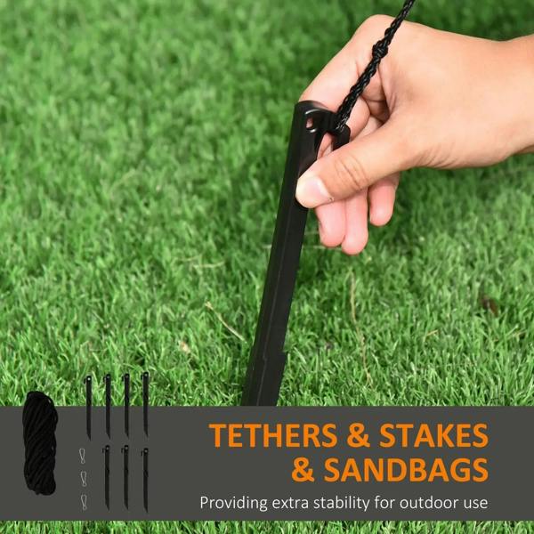 Inflatable pumpkin-ghost installation kit: black tether ropes, stakes, and sandbags on grass