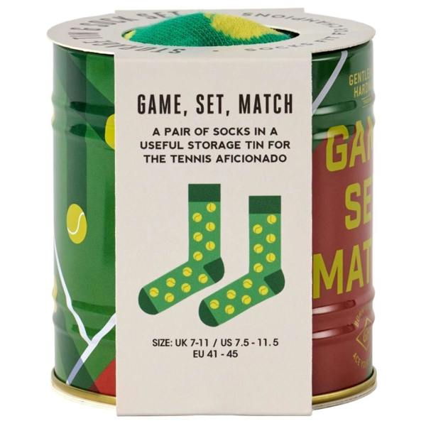The cylindrical metal storage tin for the tennis socks gift set, featuring a cream cardboard sleeve with 'Game, Set, Match' typography and an illustration of the socks.