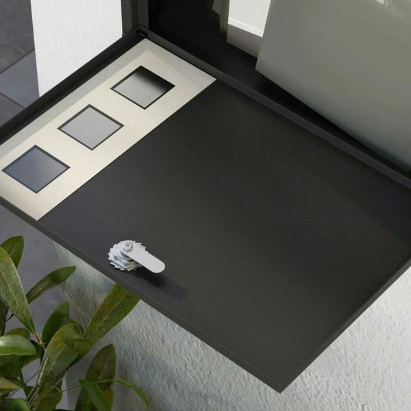 Black letterbox interior with delivery flap openings and key lock on base