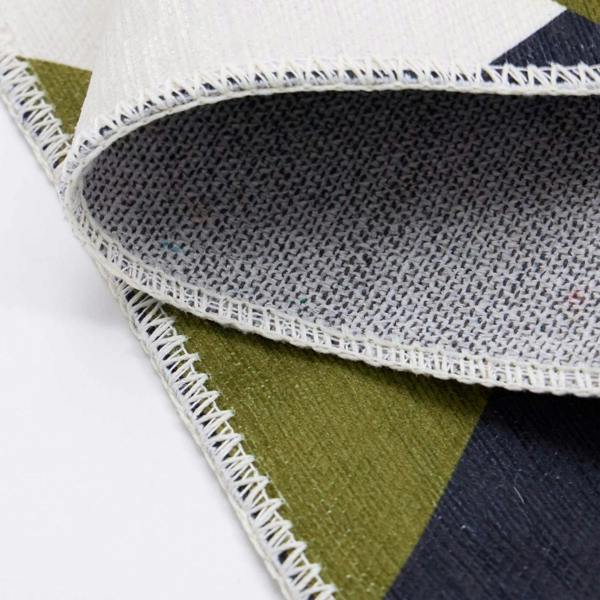 Close-up of a geometric-patterned rug with a focus on the texture and stitching.