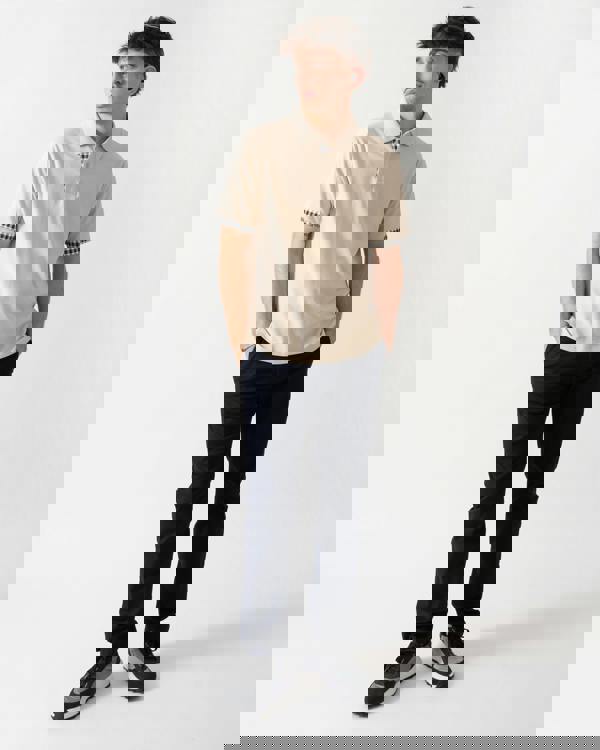 full length shot of a model wearing an Aquascutum Mens Club Check Stretch Piquet Sleeves Polo Shirt in Beige 03