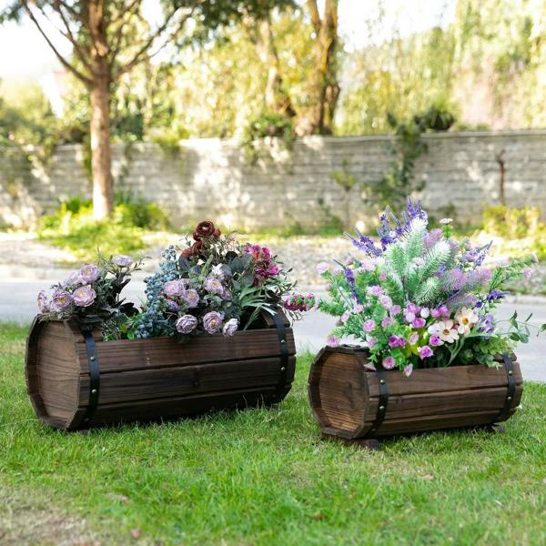 Pair of dark brown wooden planter boxes on grass, filled with mixed garden flowers