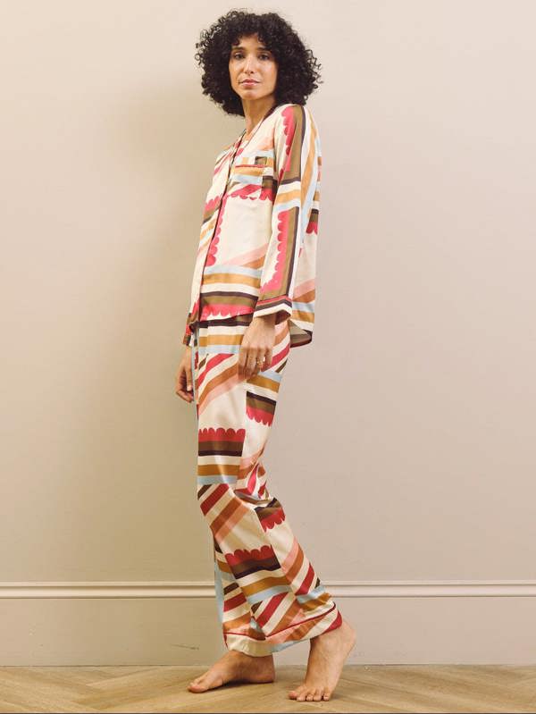 Woman wearing a patterned pyjama set against a plain background