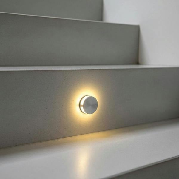 silver interior step light mounted on a grey stair riser