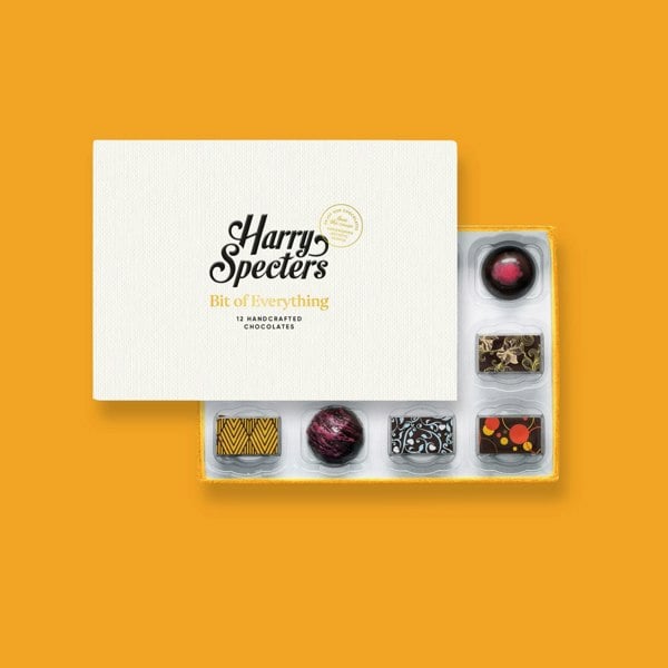 A box of 12 artisan vegan chocolates by Harry Specters partially covered by a box lid 