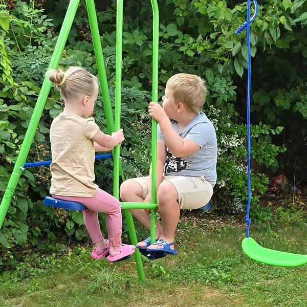 Green swing set with two toddlers on blue rope swings in a garden yard