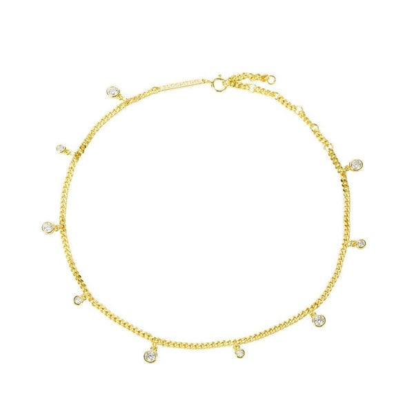 A close-up shot of the Illuminess™ Apah Water Goddess Anklet in premium gold vermeil, modeled on an olive-toned ankle. The dainty silver chain features shimmering lab-diamond droplets that catch the light, creating a liquid-sparkle effect