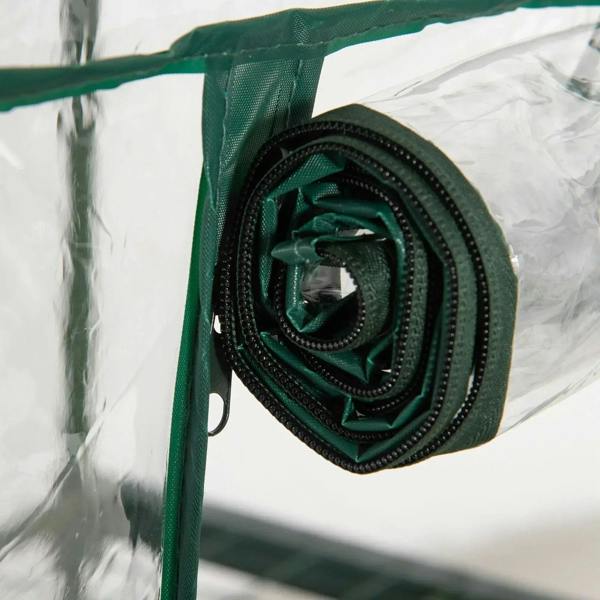 Rolled dark green greenhouse cover door with fabric securing strap