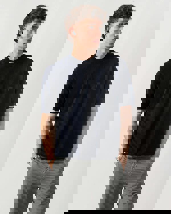 studio shot of a model wearing a BOSS Orange Kanacho Mens T-Shirt in Dark Blue 404