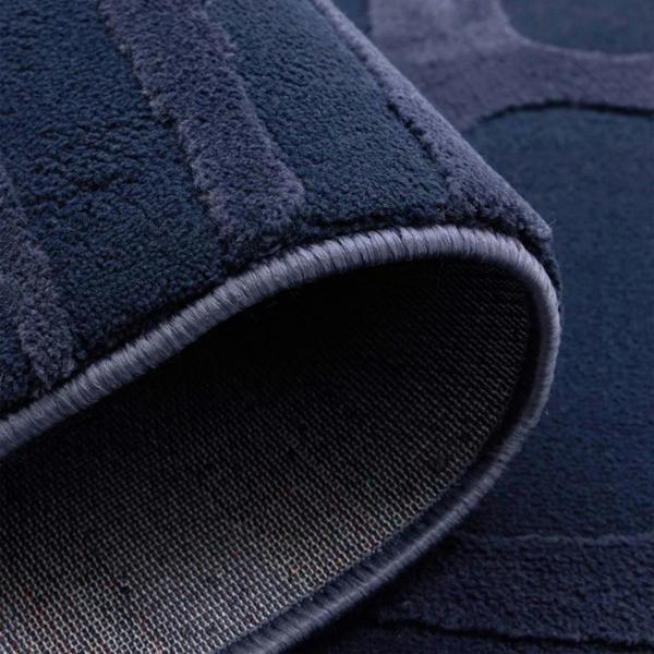 Close-up of a navy blue textured rug corner