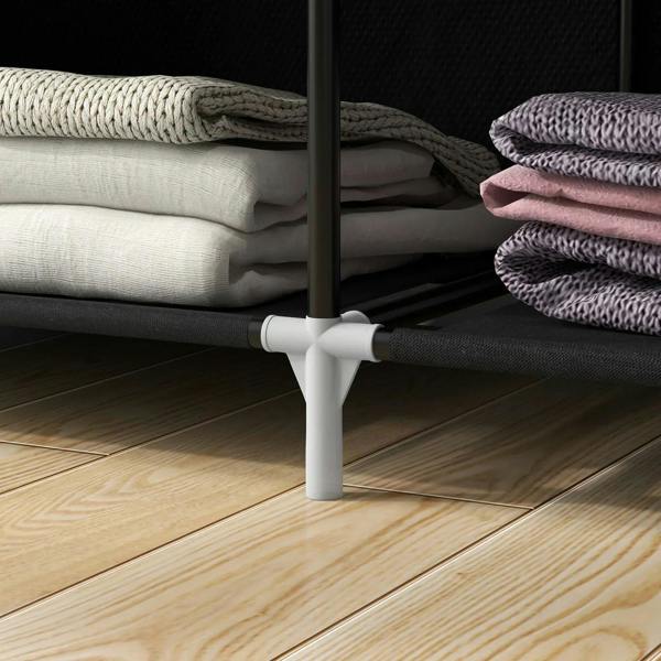 White adjustable feet and metal legs under a black fabric wardrobe for stability.