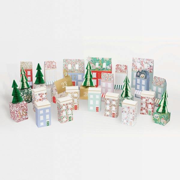 Complete 24-piece Liberty print paper village advent calendar set with house boxes and honeycomb Christmas trees against a white background.