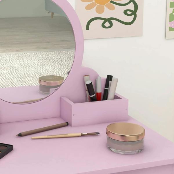 Pink vanity tabletop with organizer compartment holding makeup brushes and accessories