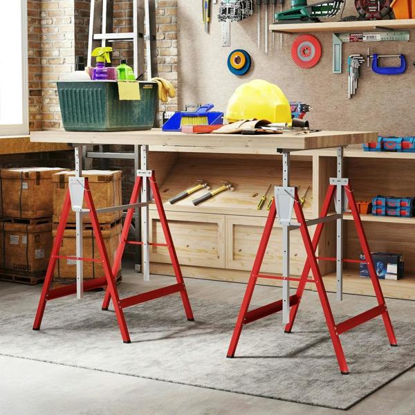Set of 2 red and gray folding sawhorses holding a wood work surface in a garage