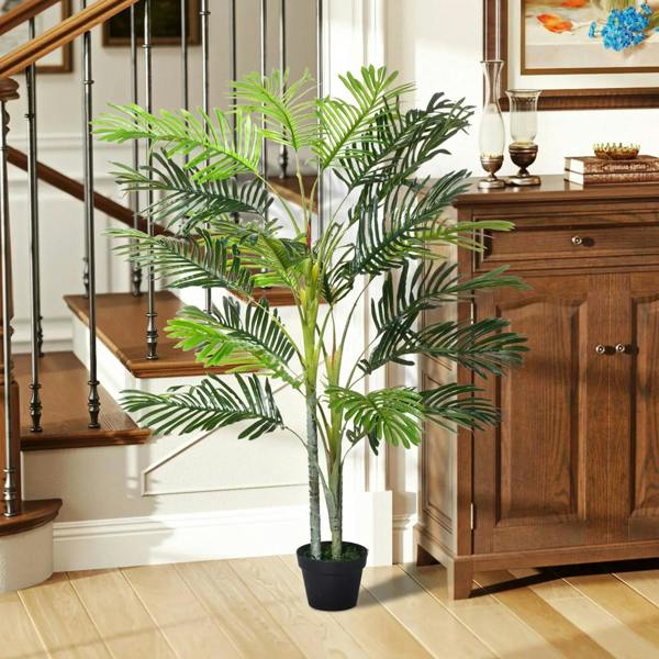 Artificial topiary tree with dark green fronds and light stems in a dark pot