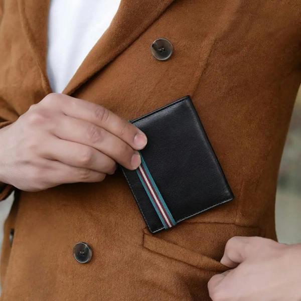 Person opening a black wallet with striped interior pocket on a brown coat.