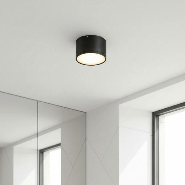 black round LED surface mount light mounted on a white ceiling in a home