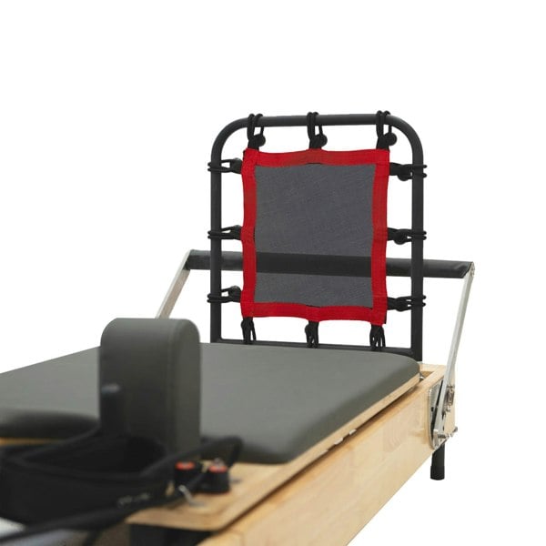 Oak Pilates reformer machine featuring a padded gray platform, adjustable red mesh headrest, and sturdy black frame for stability