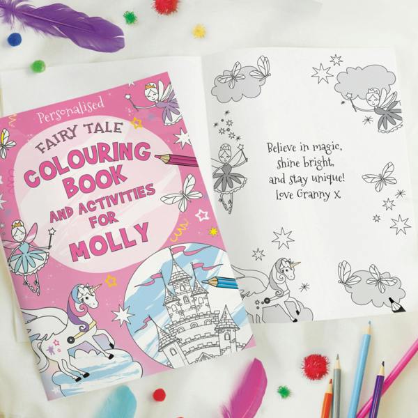 Open personalised fairy tale colouring book showing a printed personal message page alongside the front cover