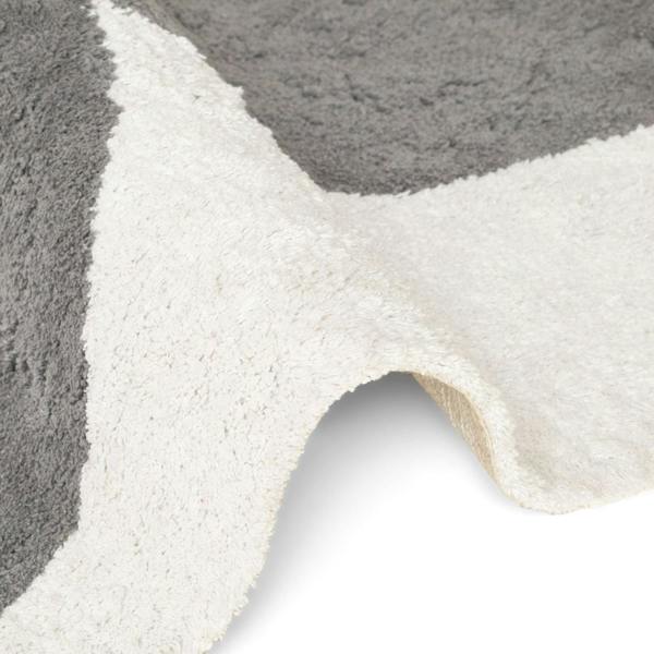 Close-up of a textured gray and white rug with a geometric pattern.