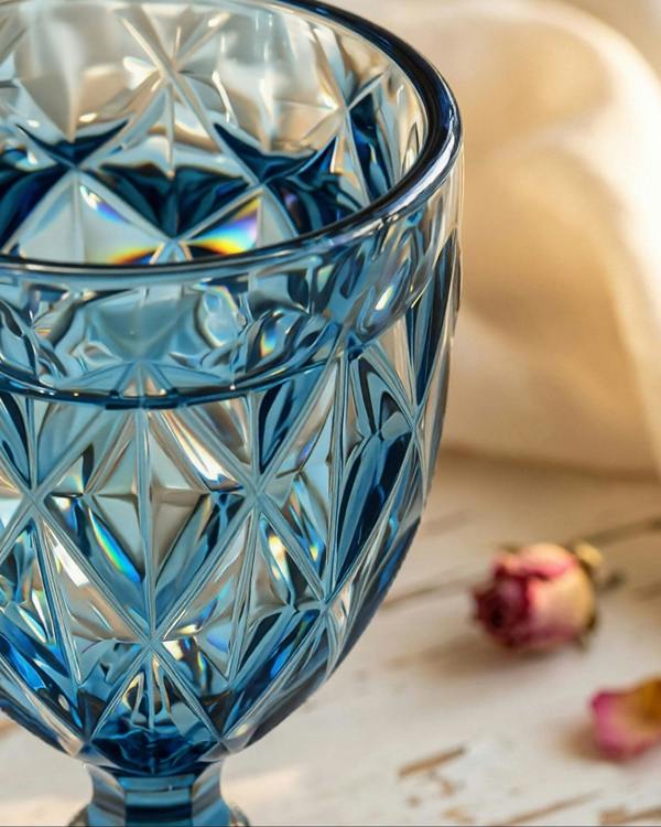 Blue crystal glass with geometric patterns on a soft beige background