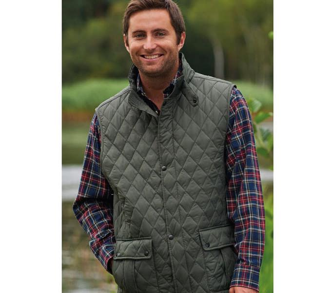 Countryman Wearing Champion Ashby Quilted Gilet in Olive in the countryside