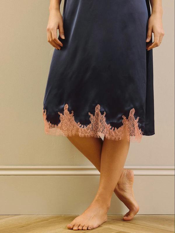Detail shot of a model wearing a navy Blue nightie with pink trim